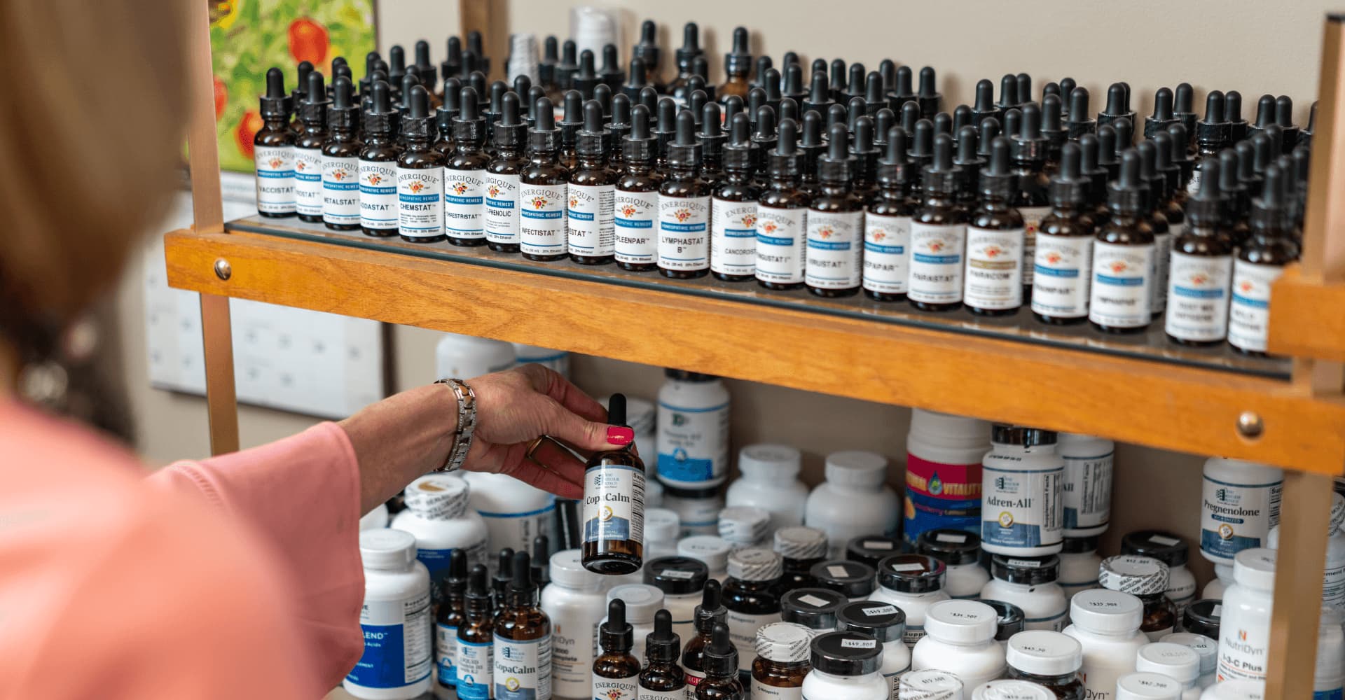 Kathy selecting a remedy from the shelves of professional-grade supplements at Stepping Stone Natural Health